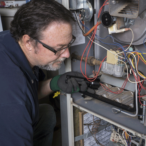 Technician Making A Furnace Adjustment